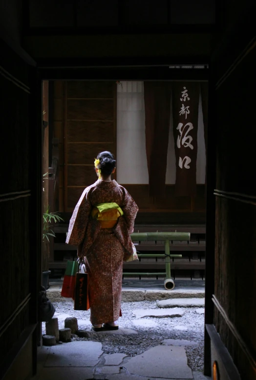 the back view of a woman in traditional costume walking through a hallway
