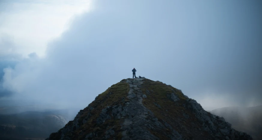 a person standing on top of a large stone mountain