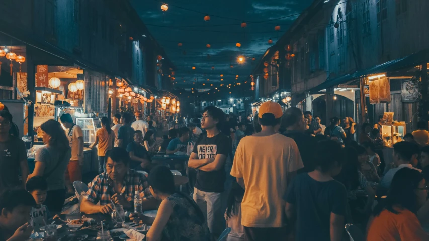 a crowded street with people shopping at an outdoor market