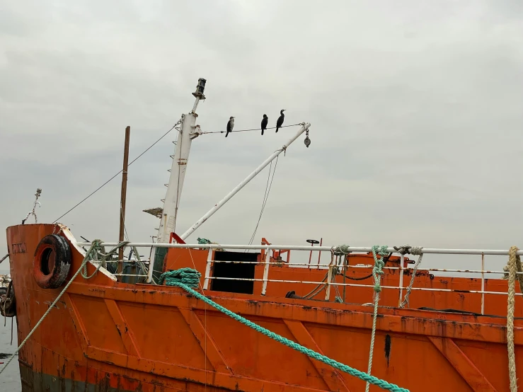 a large boat docked in the water on a cloudy day