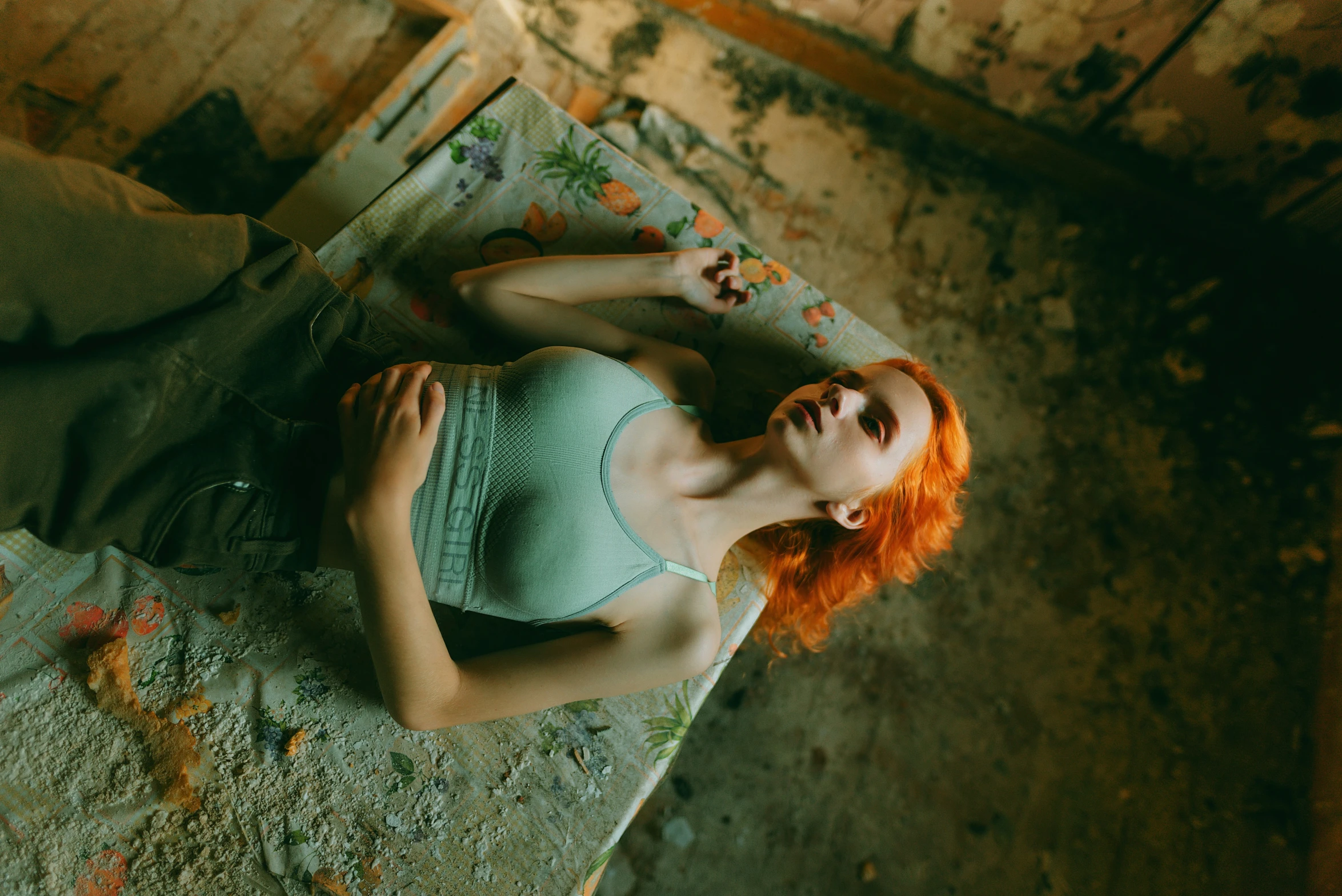 red headed woman lying on top of floor covered in dirt