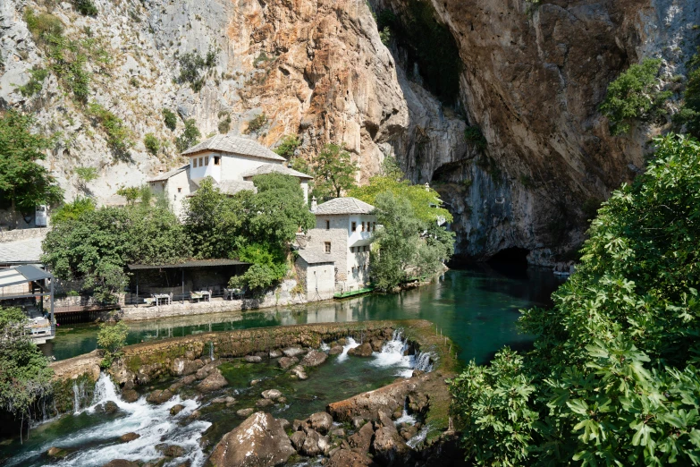 the river flows between several large mountains near a house