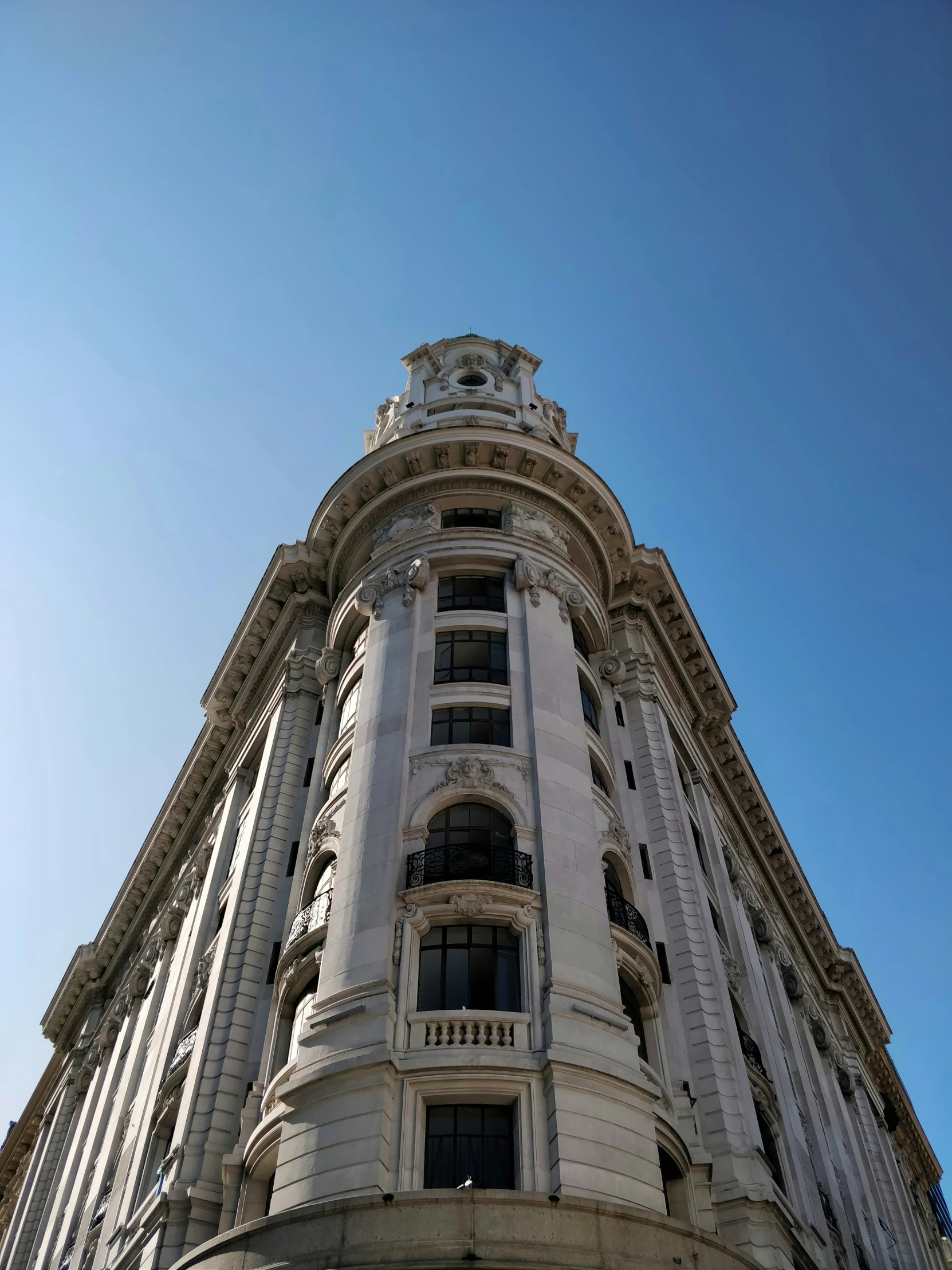 a white building with ornate decoration against a clear blue sky