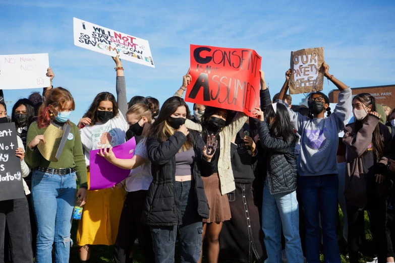 people wearing masks and holding up signs that read climate change