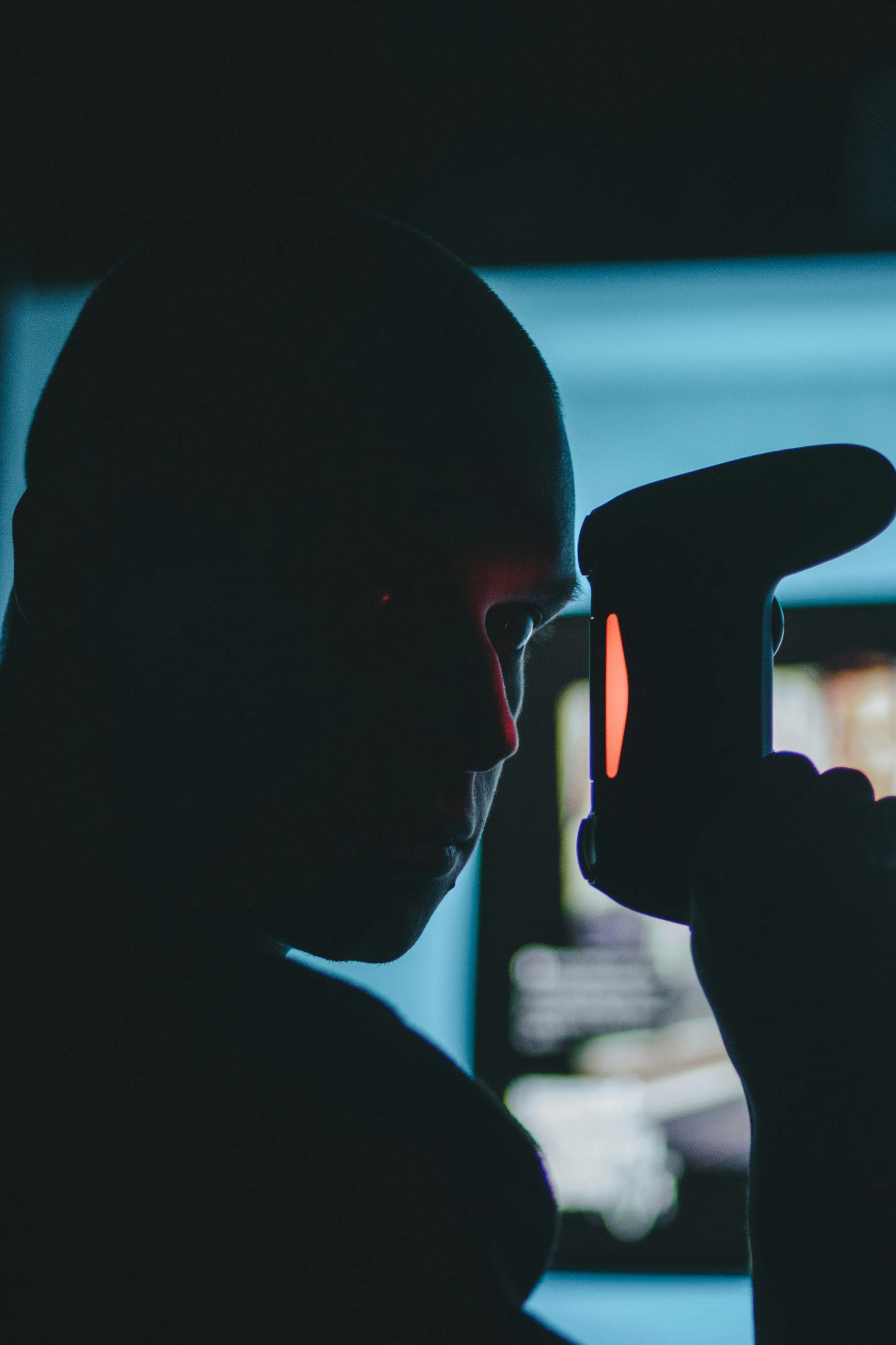 a man looking at his cell phone in the dark