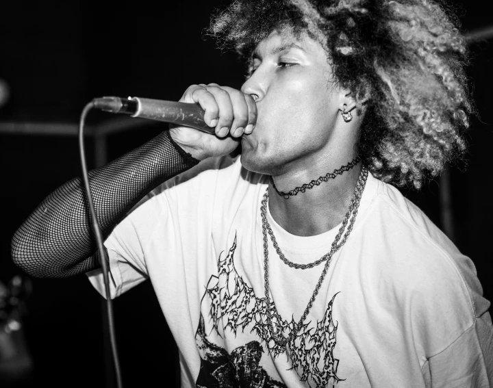 a man with curly hair holding a microphone up to his face