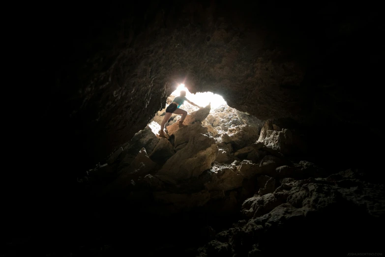 a person in a cave light with dark lighting