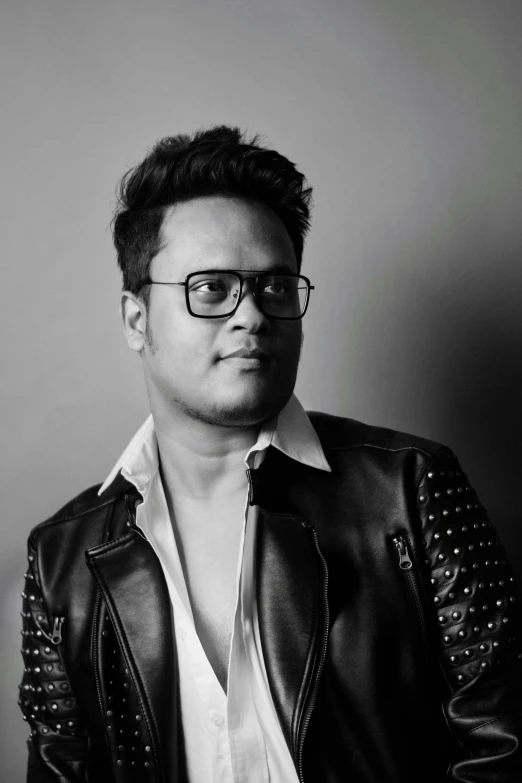 a man wearing glasses and a leather jacket