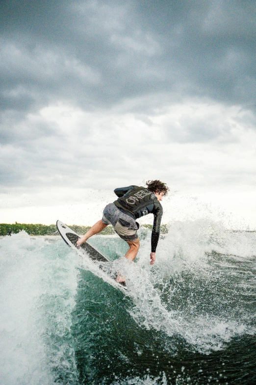 a young male surfer riding a wave on a stormy day