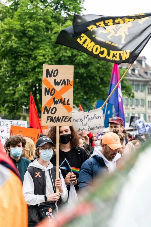 a group of people holding signs and standing in the street