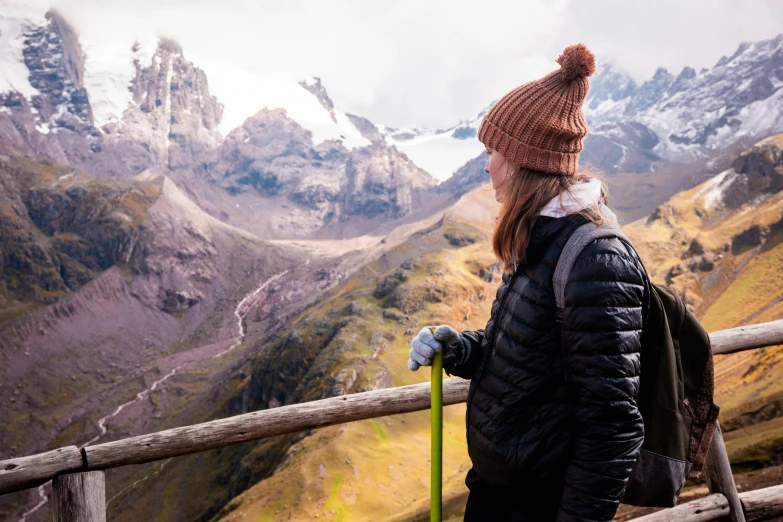 a woman with skis looking out at mountains and hills