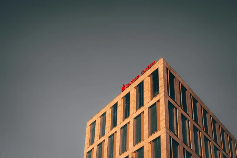 an airplane flies above a tall brown building