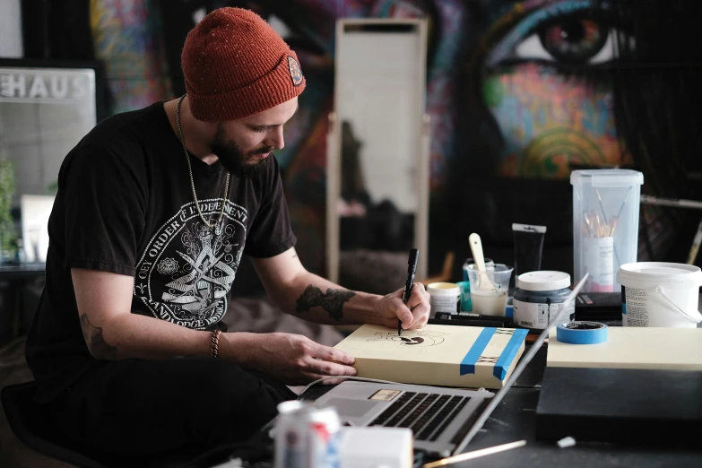 a man sitting at a table working on a laptop