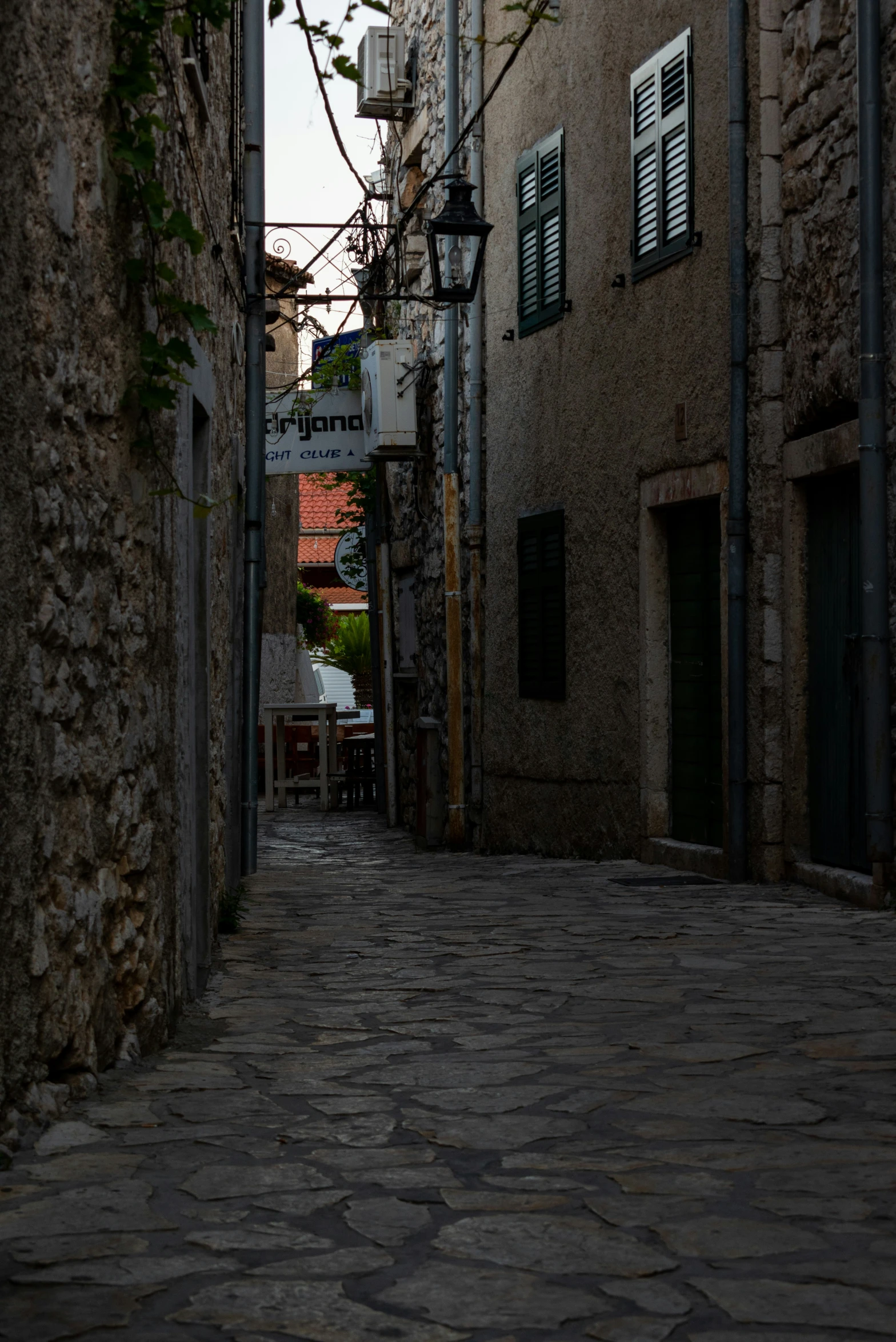 a stone street with a light on at the end of it