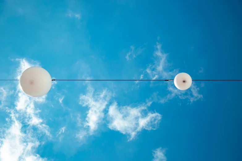 two street lights against a blue sky