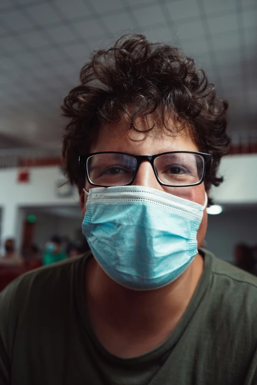 a man wearing glasses and a blue mask with no filter