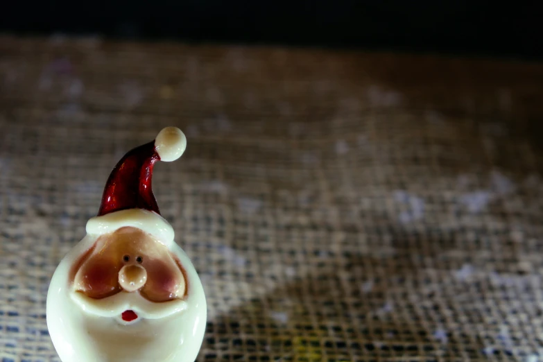 an ugly looking santa claus sitting on a piece of cloth