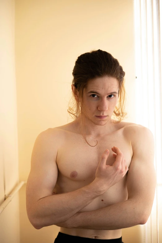 shirtless young man sitting in bathroom with his hand over the chest