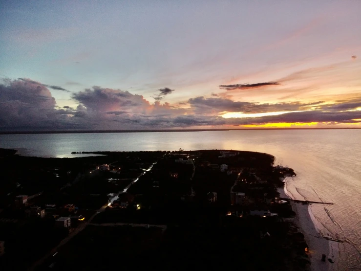 a sky view at sunset with clouds over the water