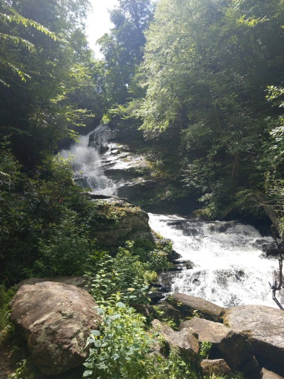 a waterfall in the middle of some rocks and trees