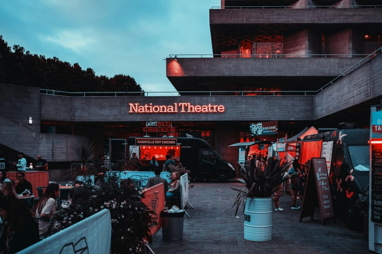 people at outdoor food stalls in a city at night