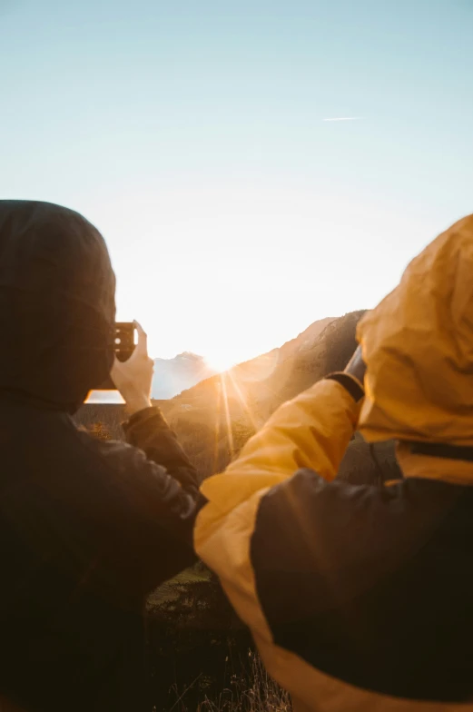 two people sitting together talking on their cellphones