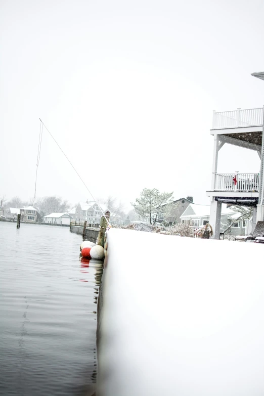 man fishing on the water while standing next to the house