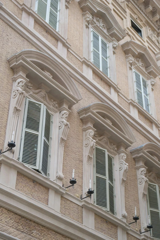 windows are seen in front of an old, beige building