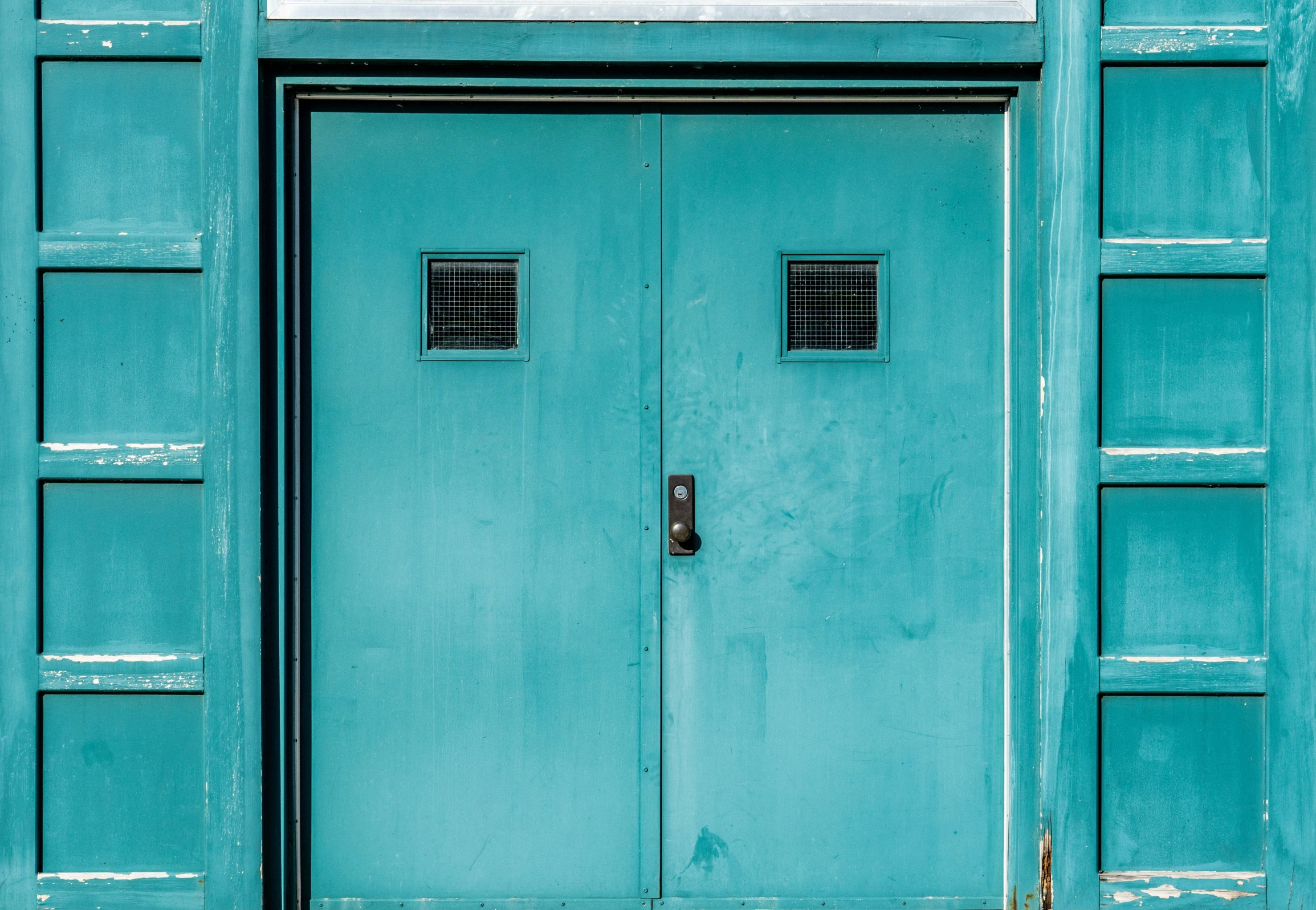 the door of a building is blue and has windows