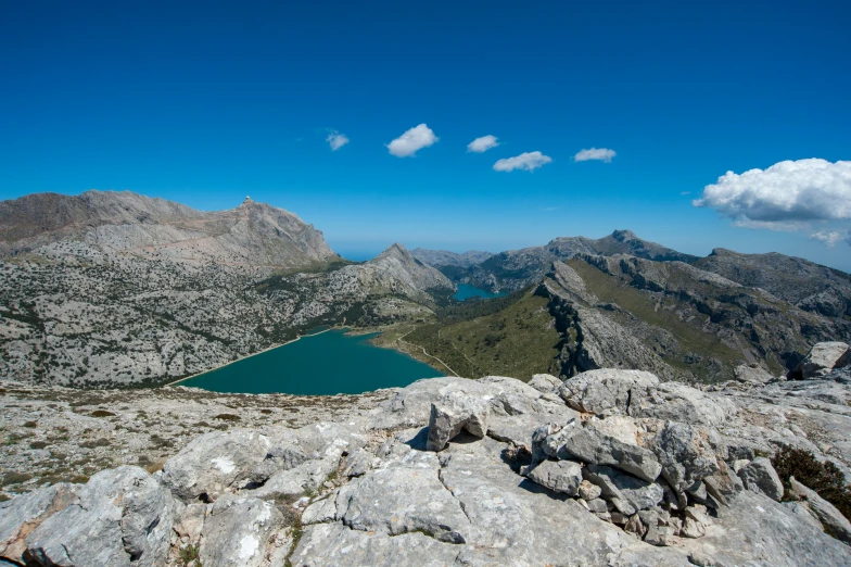 a view from the top of a mountain looking down at a lake in the distance