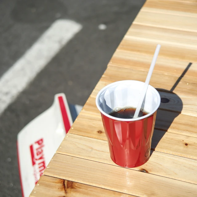 red cup of liquid sitting on wooden table