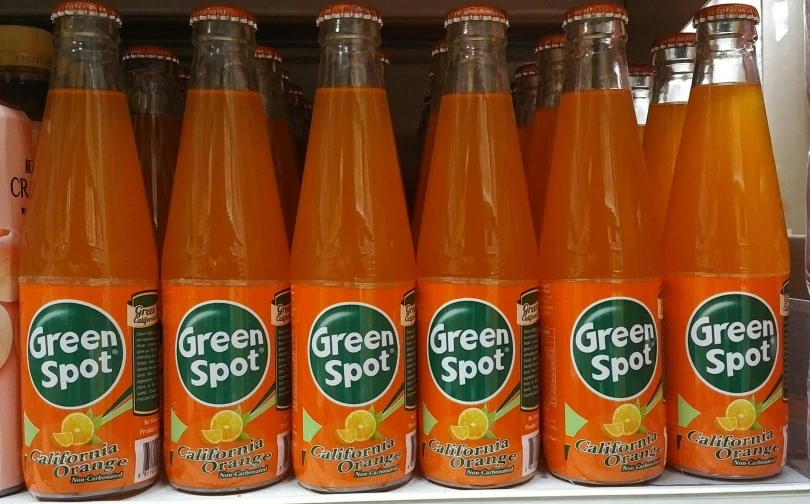 an array of orange juice in bottles on display