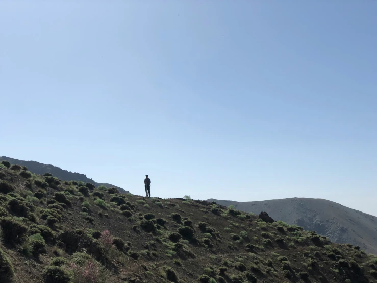 a person standing on top of a hill overlooking the ocean