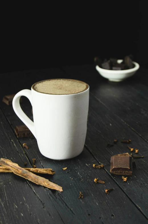 two cups on a table, one filled with spices and two other filled with brownies