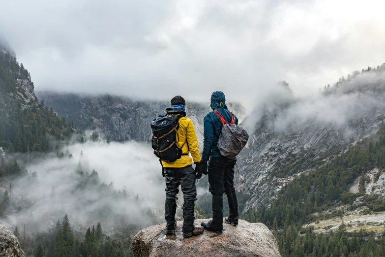 two hikers look out at a valley below