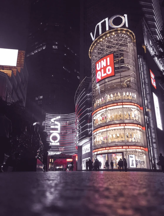 an intersection with people walking in it during the night