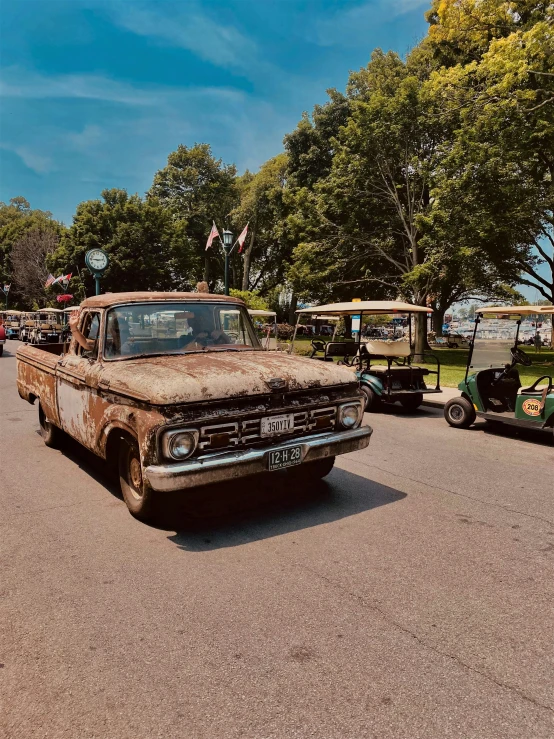 several old cars that are parked on the road