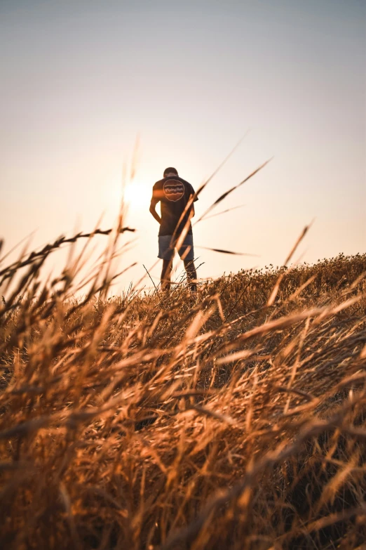 a man in a hat standing on a hill