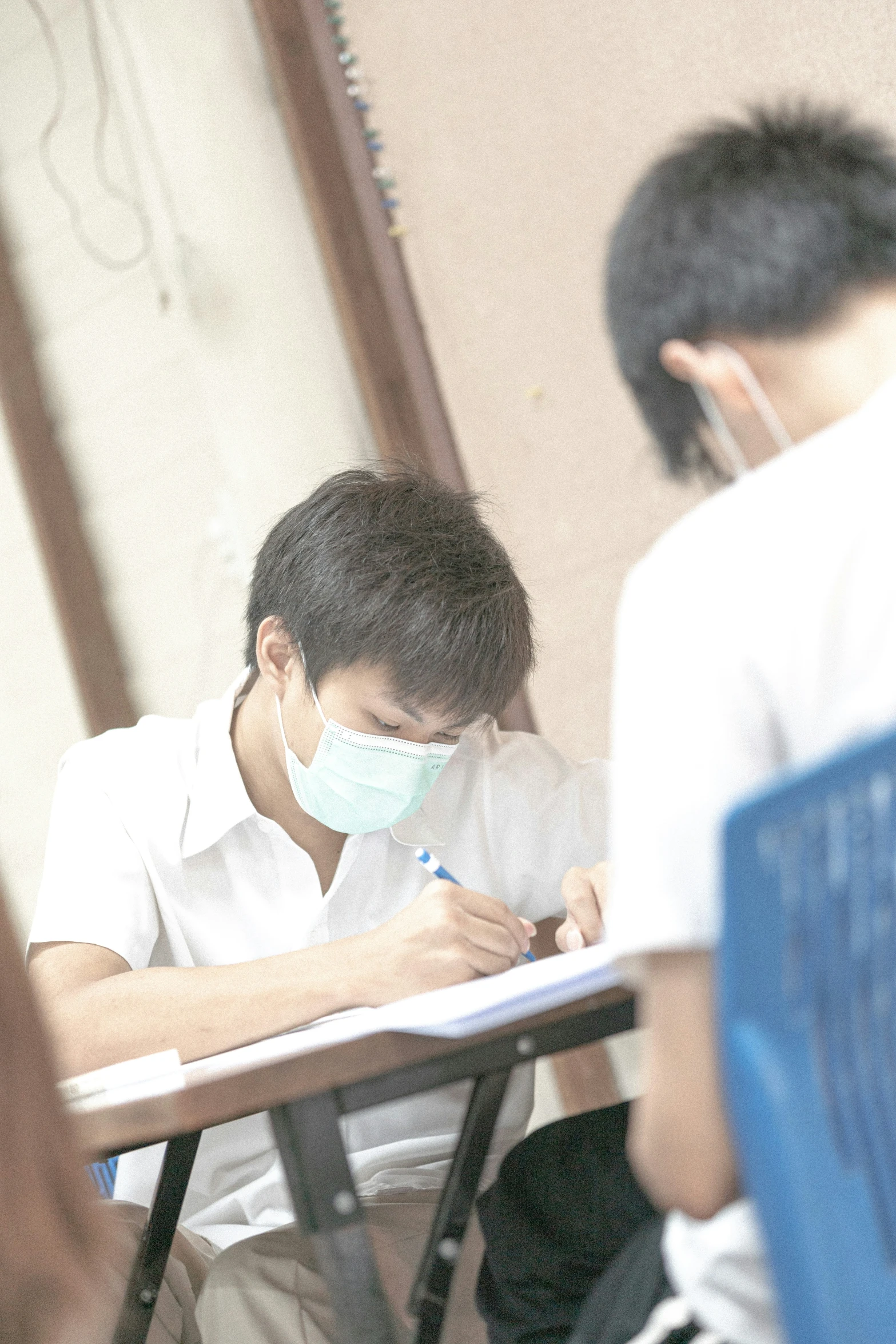 a male student in white shirt and blue chair