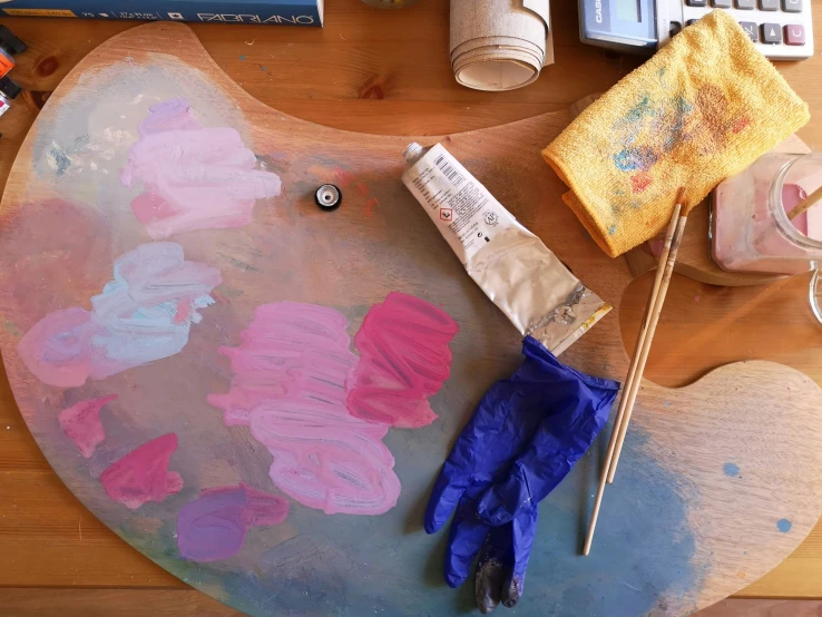 there are paint sitting on the table near an umbrella