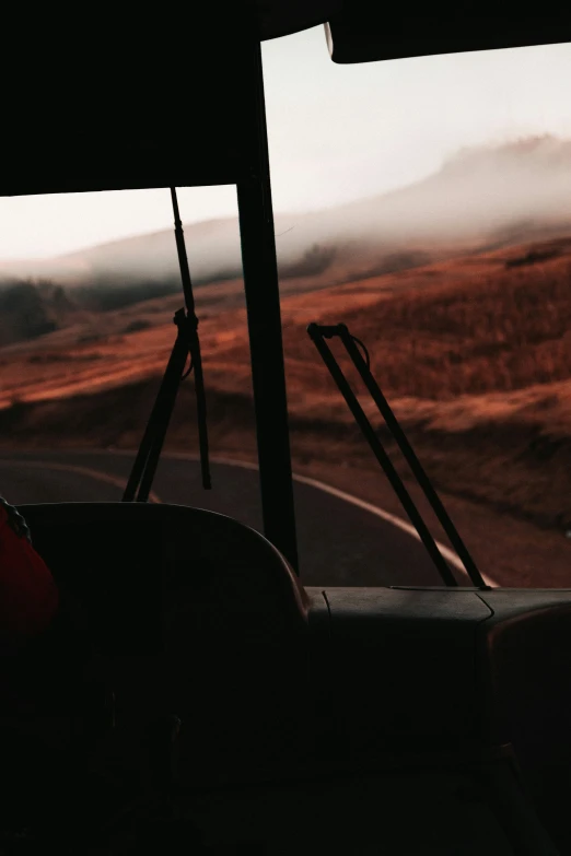 an open bus window overlooking a hilly plain