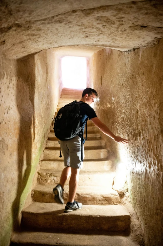 a man with a backpack walks up some stairs