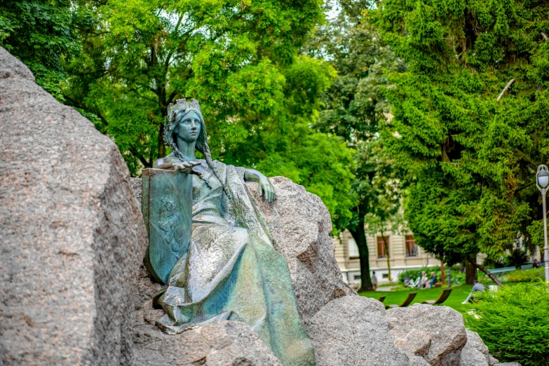 there is a statue that is sitting on top of a boulder