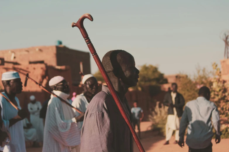 a man standing on a street while holding a stick