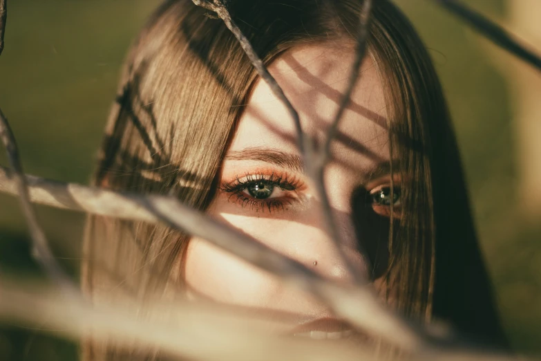 a woman looks out behind some wire fence