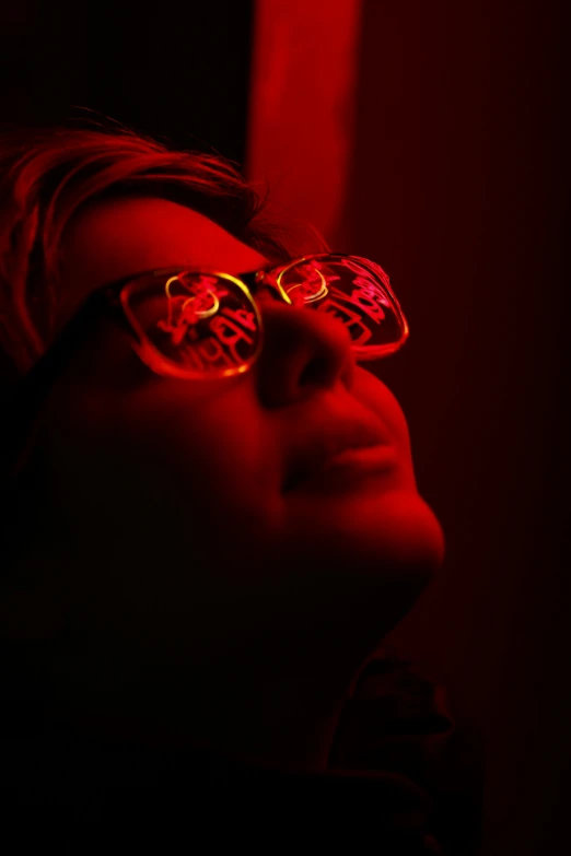 a woman wearing glasses is shown in the dark