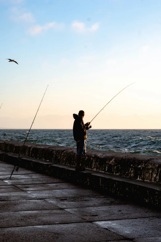 a man is fishing in the ocean near some water