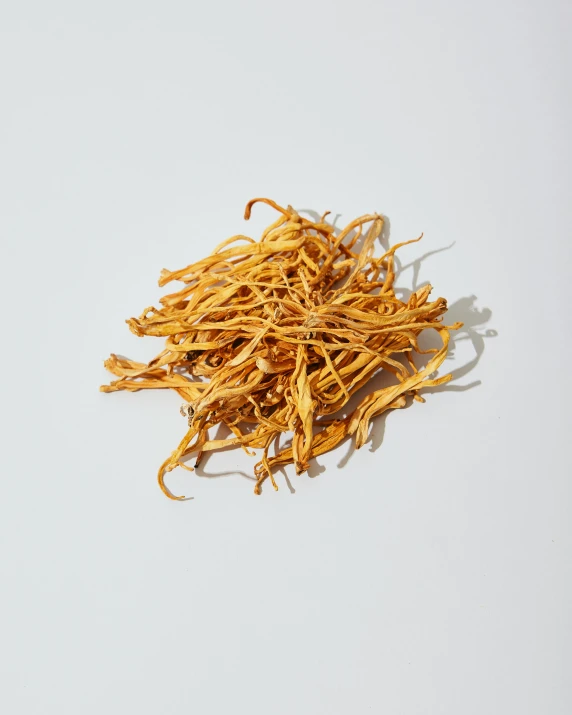 a pile of dead yellow dried oats on a white surface