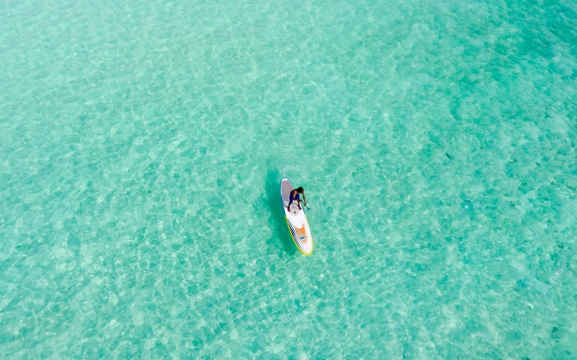 an aerial view of someone riding a surfboard in a body of water