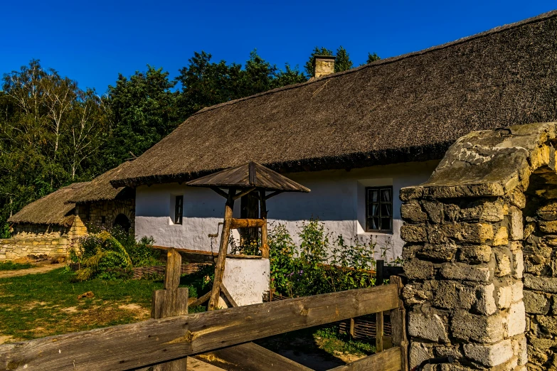 a wooden fence next to a white and gray cottage